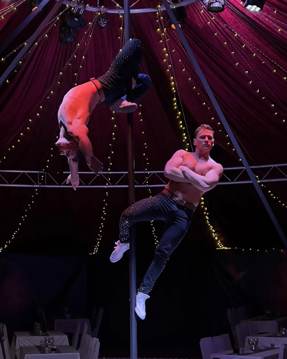 Zwei Artisten spiegelbildlich waagerecht am Chinese Pole beim Koblenzer Weihnachtscircus